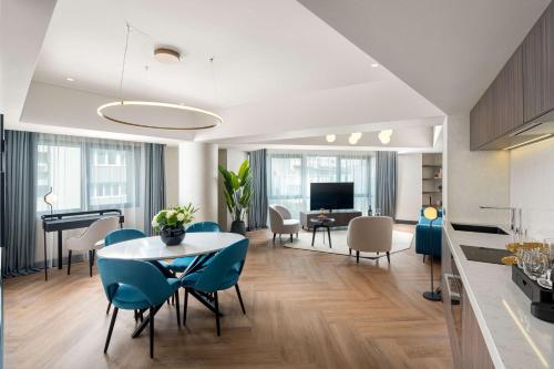 布加勒斯特布加勒斯特丽笙酒店的用餐室以及带桌椅的起居室。