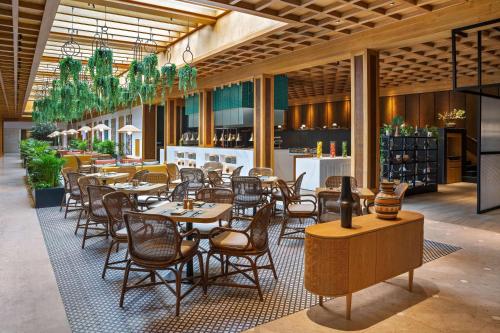 迪拜迪拜德伊勒河丽笙酒店的一间在房间内配有桌椅的餐厅