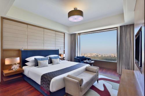 印多尔印多尔丽笙酒店的一间卧室设有一张大床和一个大窗户