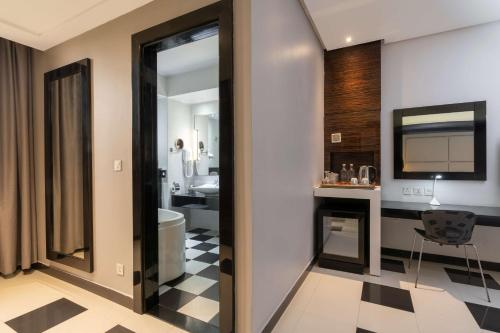 卢萨卡卢萨卡丽笙酒店的一间带卫生间、水槽和镜子的浴室