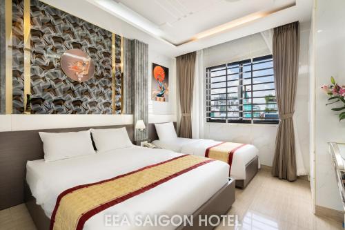 胡志明市EEA Central Saigon Hotel的酒店客房设有两张床和窗户。