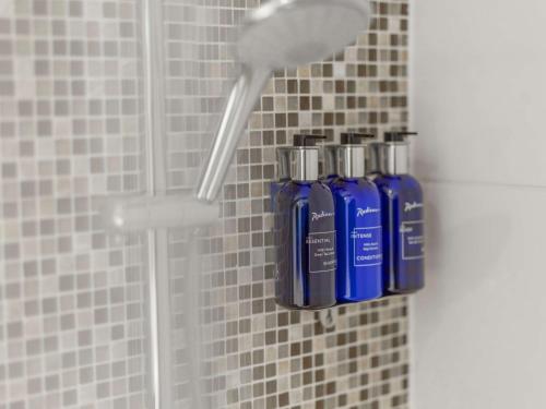 阿兰达斯德哥尔摩阿兰达阿兰迪亚丽笙酒店的两瓶蓝色的气味器正坐在淋浴里