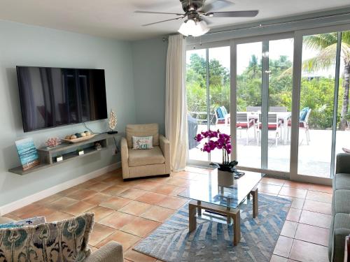 普罗维登西亚莱斯岛SeaSide Townhome, Spacious 2br 3bath Leeward Grace Bay, Providenciales, walk to beach的客厅配有电视、沙发和桌子