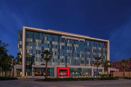 迪拜Radisson RED Dubai Silicon Oasis的一座红色门的大型办公楼