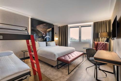 哈姆斯沃思Radisson RED London Heathrow的配有一张床和一张书桌的酒店客房