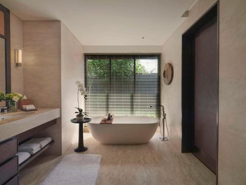 金巴兰Raffles Bali的带浴缸的浴室和大窗户