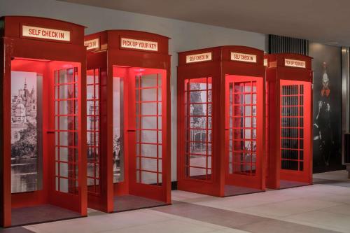 哈姆斯沃思Radisson RED London Heathrow的四个红色电话亭被排在一间房间里
