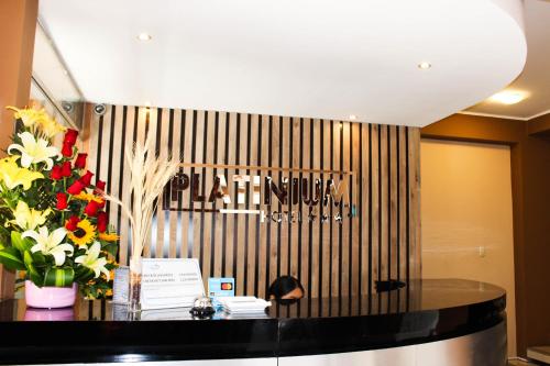 塔克纳Hotel PLATINIUM的大堂设有鲜花桌和标志