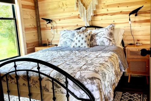 劳伦斯堡#4 Kentucky Bourbon Trail Bourbon Barrel Cottages的小木屋内一间卧室,配有一张床