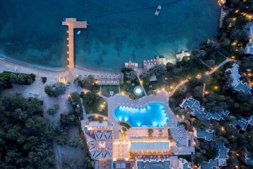 托尔巴DoubleTree by Hilton Bodrum Isil Club All-Inclusive Resort的享有度假村的顶部景色,在晚上设有游泳池