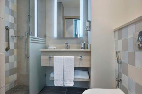 多哈Hampton By Hilton Doha Old Town的一间带水槽、卫生间和镜子的浴室