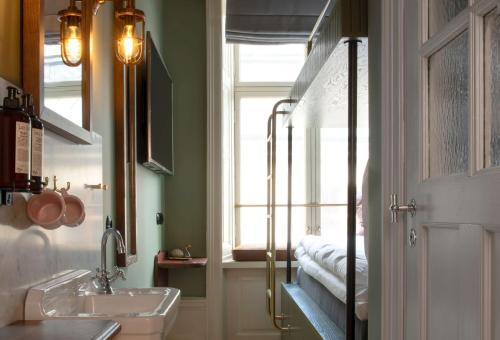 斯德哥尔摩Hotel Frantz, WorldHotels Crafted的一间带水槽和镜子的浴室以及窗户。