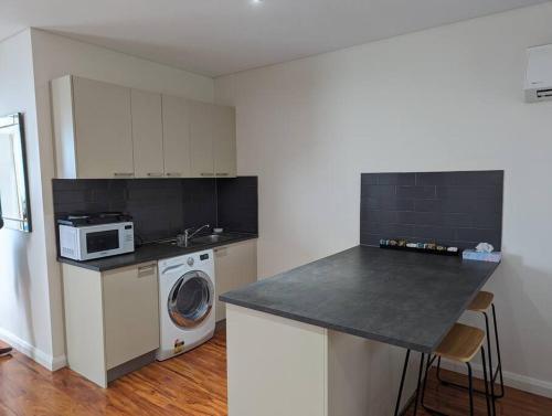 金斯顿Spacious 2 bedroom apartment @Kingston Foreshore的厨房配有洗衣机和微波炉。
