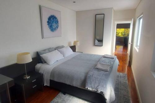 金斯顿Spacious 2 bedroom apartment @Kingston Foreshore的一间卧室配有床、灯和窗户