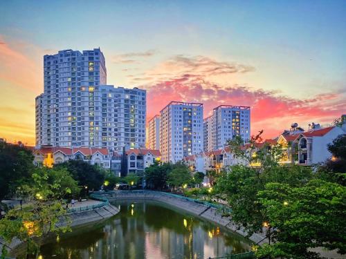 胡志明市LAKEVIEW Park Villa - Private Pool, BBQ, Karaoke的一座拥有高楼和日落河流的城市