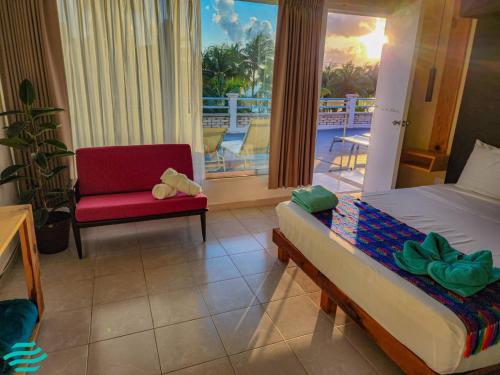 女人岛Antillas的一间带一张床和一把椅子的卧室以及一个阳台