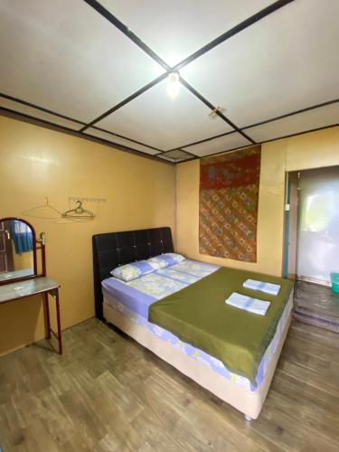 刁曼岛Sri Sentosa Chalet的卧室配有一张床铺,位于带桌子的房间
