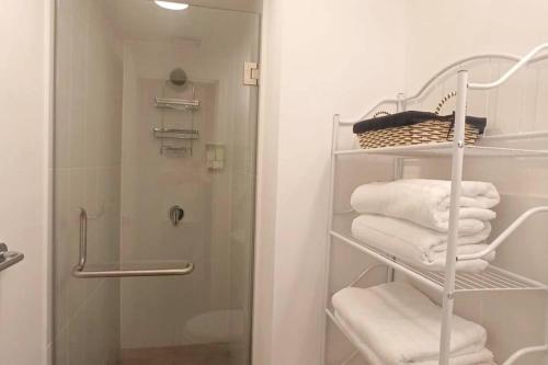 危地马拉Encantador y Panorámico Apartamento的带淋浴的浴室以及带毛巾的架子。
