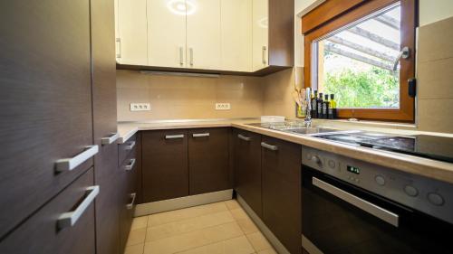 弗济内Kuća za odmor KRISTINA的厨房配有棕色橱柜、水槽和窗户。