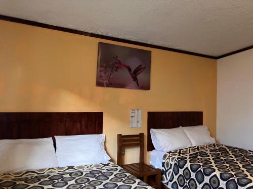 奇格纳瓦潘Hotel Santa Fe的酒店客房设有两张床,墙上挂着一张照片。