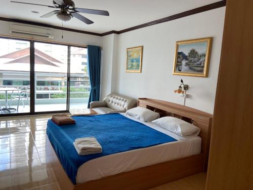 南芭堤雅特雷5号观景农公寓的一间卧室配有一张带蓝色毯子的大床
