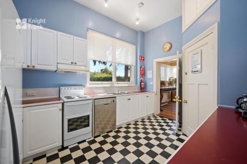 霍巴特克莱兹代尔庄园酒店的厨房配有白色橱柜和 ⁇ 格地板