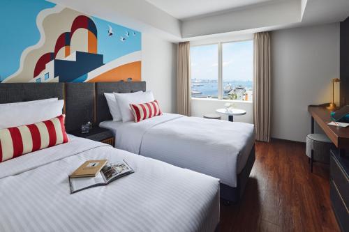 横滨Citadines Harbour Front Yokohama的酒店客房设有两张床和窗户。