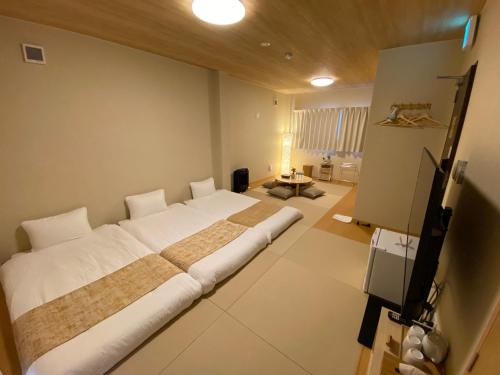 新宫市AJITO Hostel & CafeBar的一间卧室,卧室内配有一张大床
