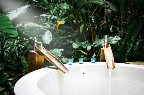 湄林普劳德普发希普与格林度假酒店的浴缸配有2个水水龙头和2个饮酒杯