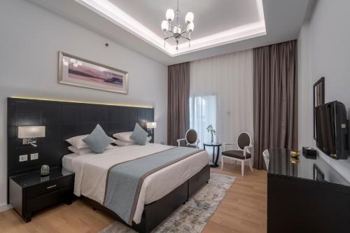 迪拜Rose Garden Hotel Apartments - Al Barsha, Near Metro Station的酒店客房,配有床和电视