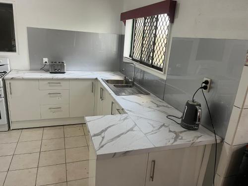 努库阿洛法汤加假日别墅 的白色的厨房设有水槽和台面
