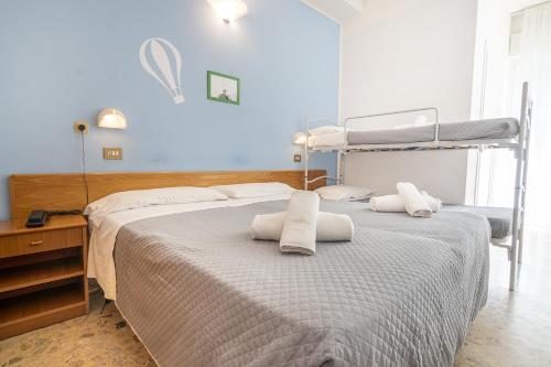 里米尼Hotel Santiago的一间卧室配有两张带毛巾的床