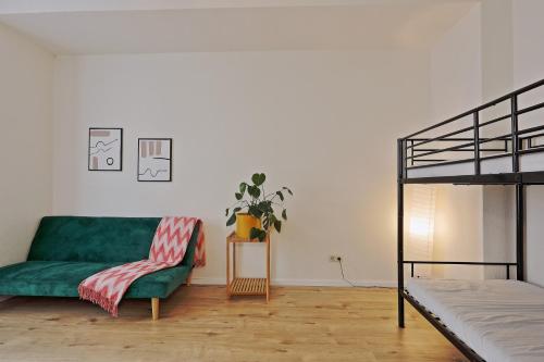 杜伊斯堡NEXT HOME - FREE Parking & WiFi - Badewanne的客厅配有绿色沙发和床。