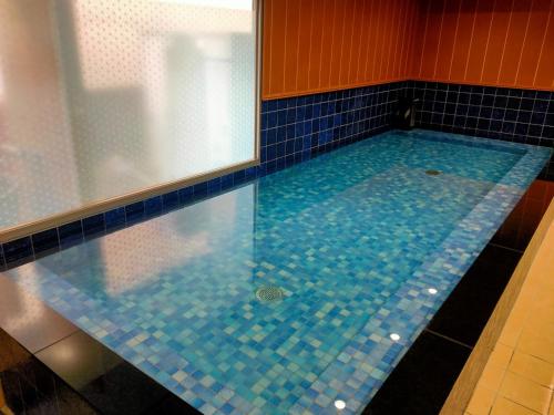 名古屋HOTEL ERENOA - Vacation STAY 69058v的拥有蓝色瓷砖墙壁和蓝色瓷砖的游泳池
