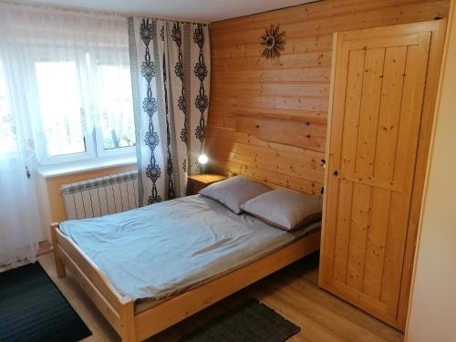 Grywałd与伯泽娜和艾德克特卡兹克一起度假农家乐的一间卧室配有一张木墙床