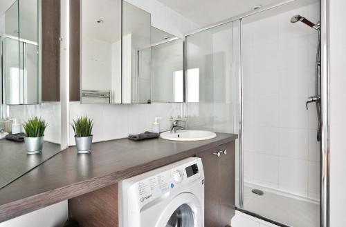 巴黎Appartement Quartier Republique的一间带盥洗盆的浴室内的洗衣机