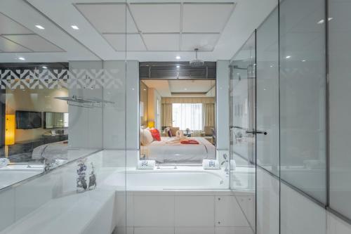 迪拜Majestic Premier Hotel Burdubai的带浴缸的浴室和卧室
