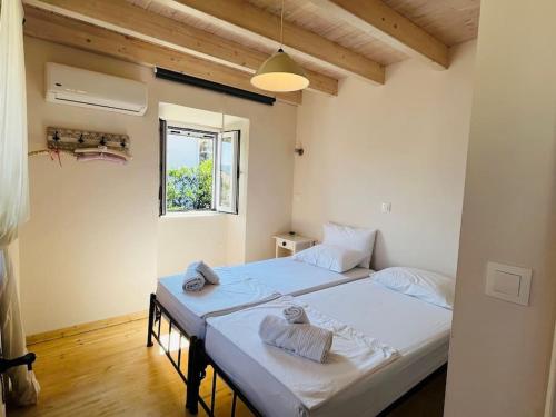 里亚帕德斯Traditional Detached Corfu House, 50m to village square的一间卧室配有两张带毛巾的床