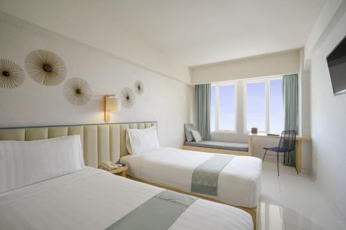 库塔库塔索啦丽思酒店的酒店客房设有两张床和窗户。
