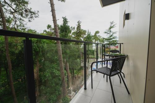 乌雷基Ritsa Resort的一个带椅子并享有树林美景的阳台