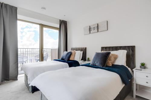 曼彻斯特3 bed luxury spacious apartment with pool的带阳台的卧室内的两张床