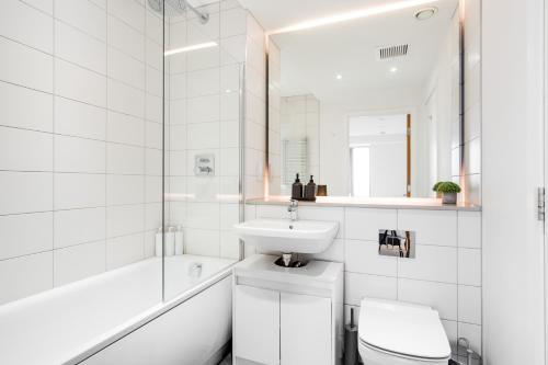曼彻斯特3 bed luxury spacious apartment with pool的白色的浴室设有水槽和卫生间。
