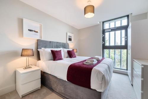 泰晤士河畔金斯顿Roomspace Serviced Apartments- Buttermere House的一间卧室设有一张大床和一个窗户。
