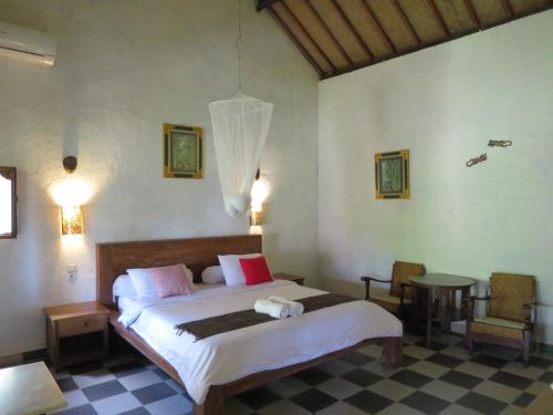塔巴南Kebun Villa, Belimbing, Bali的卧室配有一张床和一张桌子及椅子