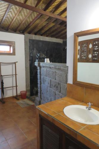 塔巴南Kebun Villa, Belimbing, Bali的一间带水槽和砖砌壁炉的浴室