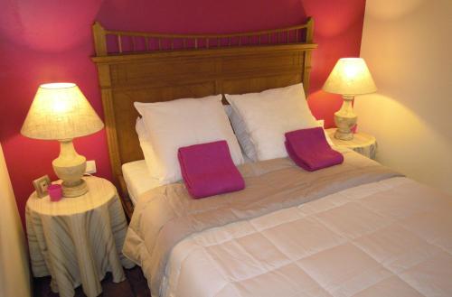 韦姆La Cachette du Menuisier的一间卧室配有一张带两个枕头的床