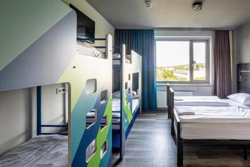 魏玛魏玛A&O酒店的客房设有两张双层床和一扇窗户。
