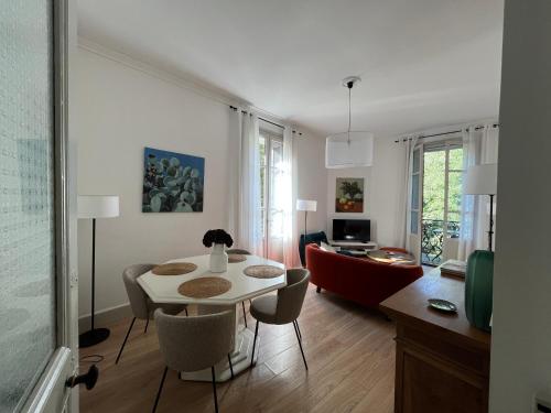 尼姆Nimes , appartement rénové dans immeuble classé.的客厅配有白色的桌子和椅子