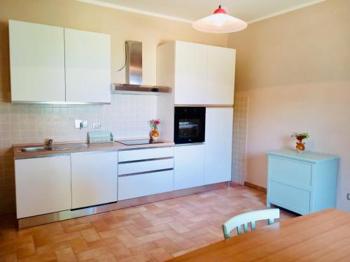 托迪Colle Costanza的厨房配有白色橱柜和木桌