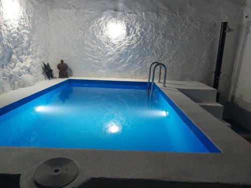 BenadalidCasa rural El Patio的楼梯间蓝色的游泳池